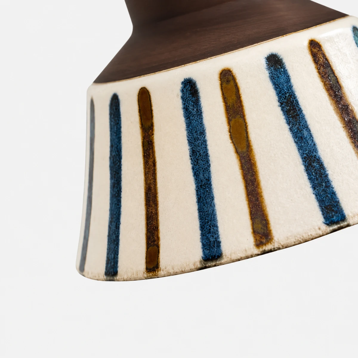 Close view of the striped ceramic glaze and warm brown rim