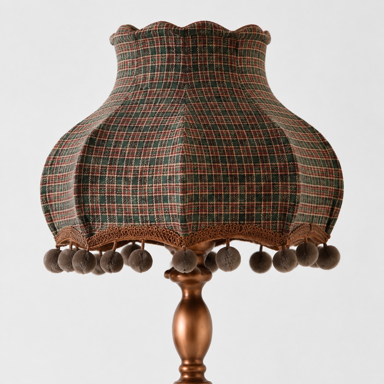 Close-up of blue orange check pleated shade with scalloped edge and pom-pom trim