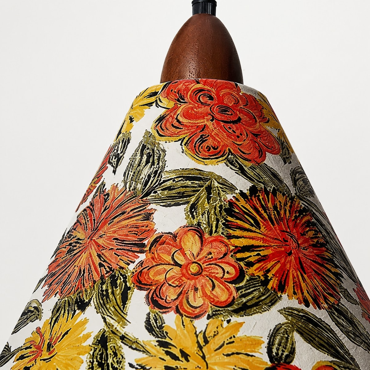 Närbild av den blommiga tygpendelskärmen och den varma glödlampan
